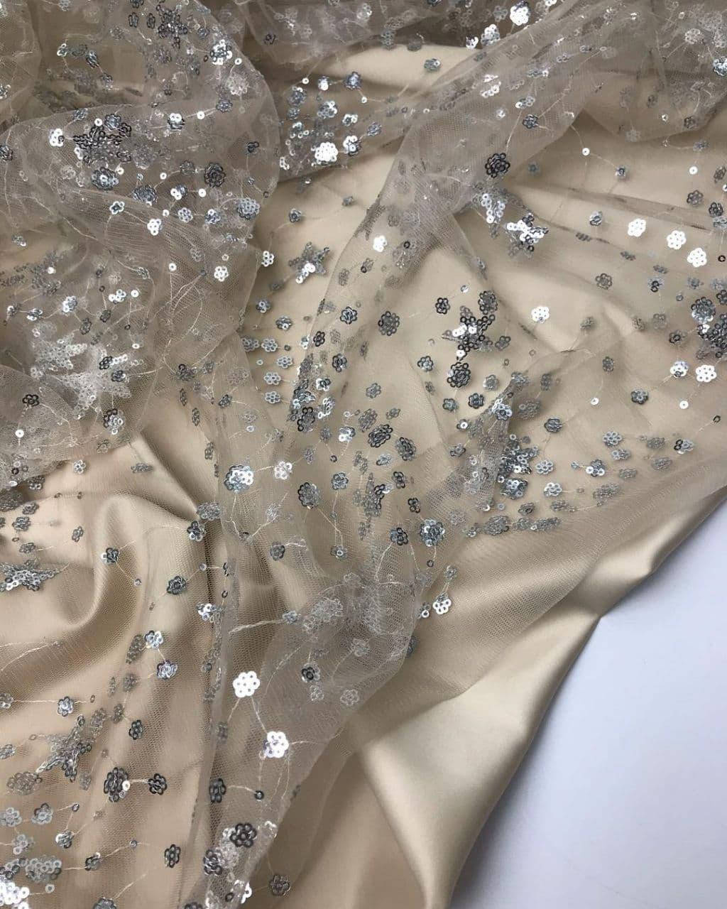 

Сетка телесного цвета с легким узором из пайеток, пайетки на сетке. Ніжный блестящий узор на ткани