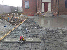 Перед укладкой бетона (точнее, перед началом работ по планировке) вся территория была размечена с помощью нивелира. Бетон принимался по ниткам. Точность в пределах 10 мм (ввиду того, что сверху будет тротуарная плитка).