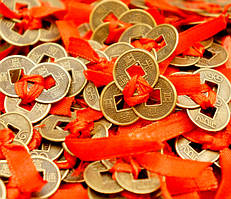 Три монети перев'язані червоною ниткою трикутником