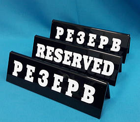 Настільна табличка з білим написом "RESERVED/РЕЗЕРВ"