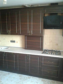 Фасады фрезерованные, пленочные. Цвет темный под дерево. Светлая столешница контрастно выделяется в композиции.