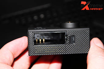 Отсек для аккумуляторной батареи без рёбрышек. 
Также обратите внимание на линзу камеры, она выпуклая, за счет этого у камеры SJ4000 угол обзора 170 градусов.