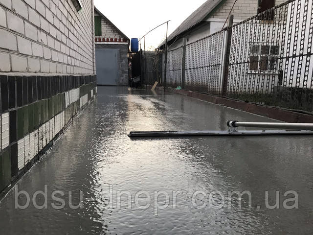 Розрівнювання бетону у дворі канальної гладилкою