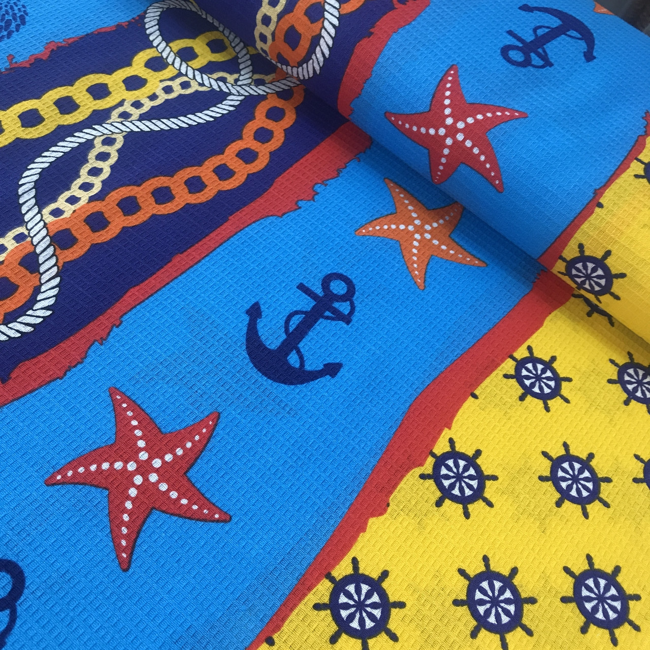 Вафельна тканина з морськими зірками, штурвалами та якорями, ширина 150 см