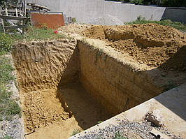 Копка ями під підвальне приміщення у приватному секторі на Комунарі. Грунт (переважно глина) складувався з одного боку.