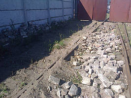 При виїмці ґрунту цегла та інше будівельне сміття було складено осторонь, щоб при зворотному засипанні не пошкодити кабель.