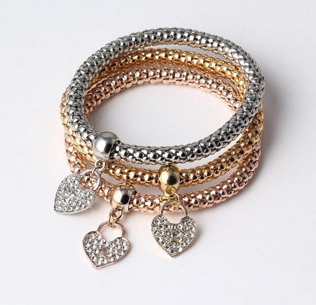 Набір із трьох браслетів із підвісками "Сердечка" золото, срібло, бронза