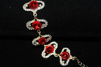 Оригінальний вечірній браслет золотистий з червоними каменями