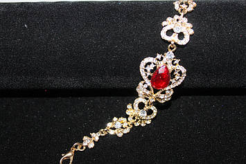 Чудовий золотистий браслет з червоними каменями гірський кришталь