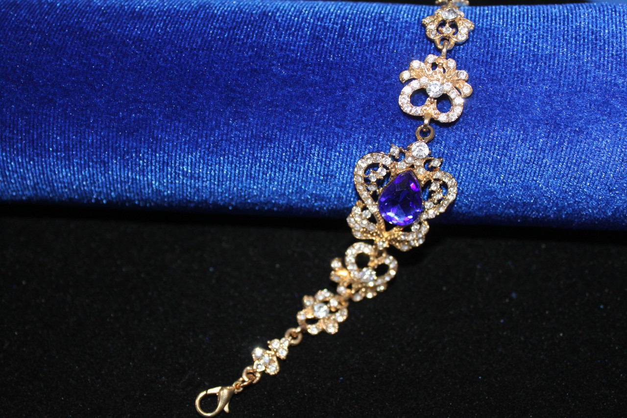 Привабливий золотистий браслет з синіми каменями