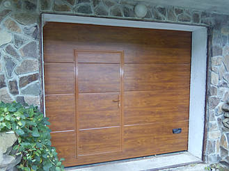 Секционные гаражные ворота Ритерна со встроенной калиткой в цвете золотой дуб с гладким типом полотна SLICK.