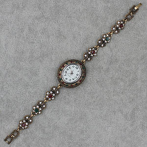 Женские часы наручные овальные кварцевые бижутерный сплав металл в золотистом цвете с разноцветными камнями