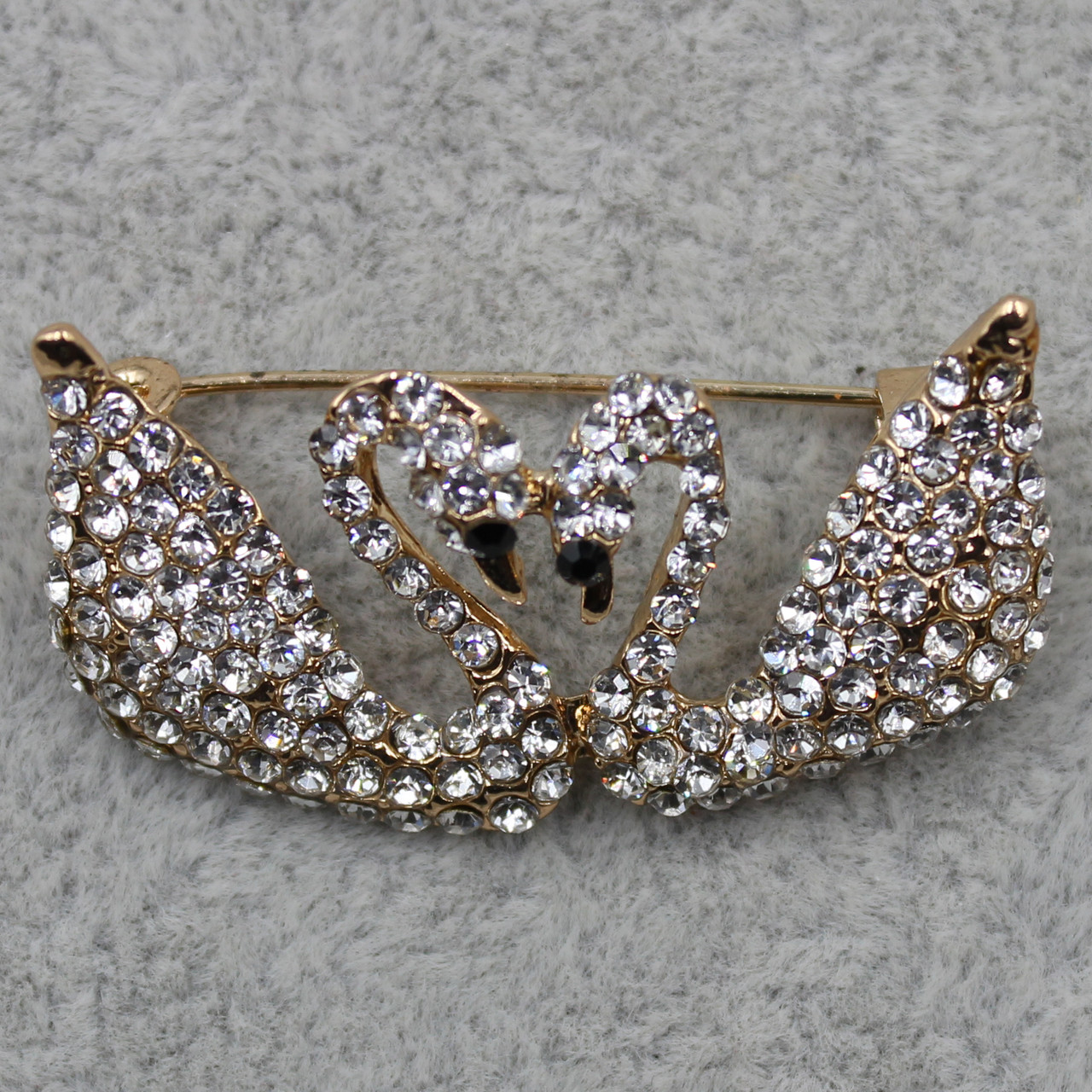 Брошка металева на золотистій основі два лебеди з білими кристалами розмір виробу 37х20 мм