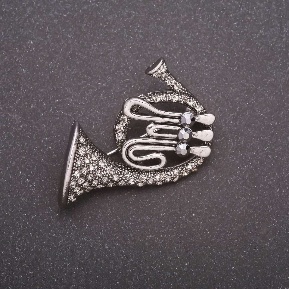 Брошка Труба в стразах сірий метал 42х45мм купити біжутерію гуртом в інтернеті