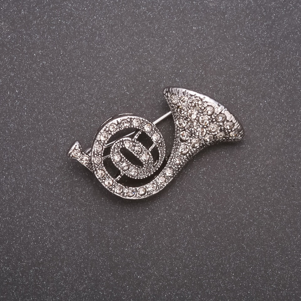 Брошка Труба в стразах сірий метал 30х20мм купити біжутерію гуртом в інтернеті