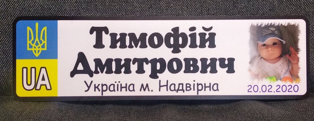 Номер на коляску з ім'ям по батькові дитини, його фотографією а також зазначенням міста та дати народження