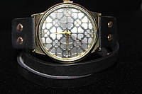 Чудовий годинник із великим золотистим корпусом на довгому чорному ремінці