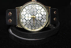 Чудовий годинник із великим золотистим корпусом на довгому чорному ремінці