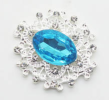 Камінь в сріблястій ажурній оправі 24*26 мм блакитний