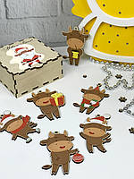 Яскраві новорічні іграшки на ялинку з зображенням символу року в дерев'яній коробці