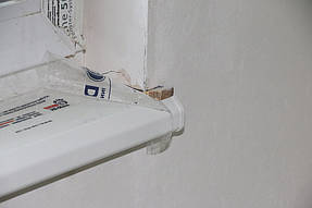 По бокам на 2 см примерно он заходит в откос с каждой стороны. 
Это сделано для более устойчивой посадки подоконника. 
Так он будет выдерживать гораздо больший вес и его нельзя будет подорвать.