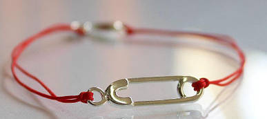 Серебряная булавка на красной нитке