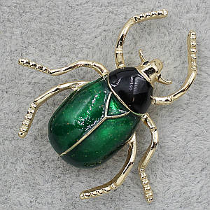 Брошка металева золотиста покрита зеленою емаллю, що переливається, розмір виробу 35х38 мм