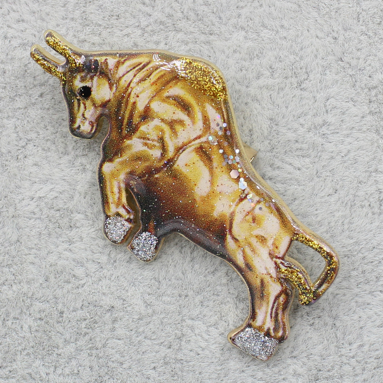 Брошка металева на золотистій основі бик із блискіточками покритий лаком розмір виробу 25х5 мм
