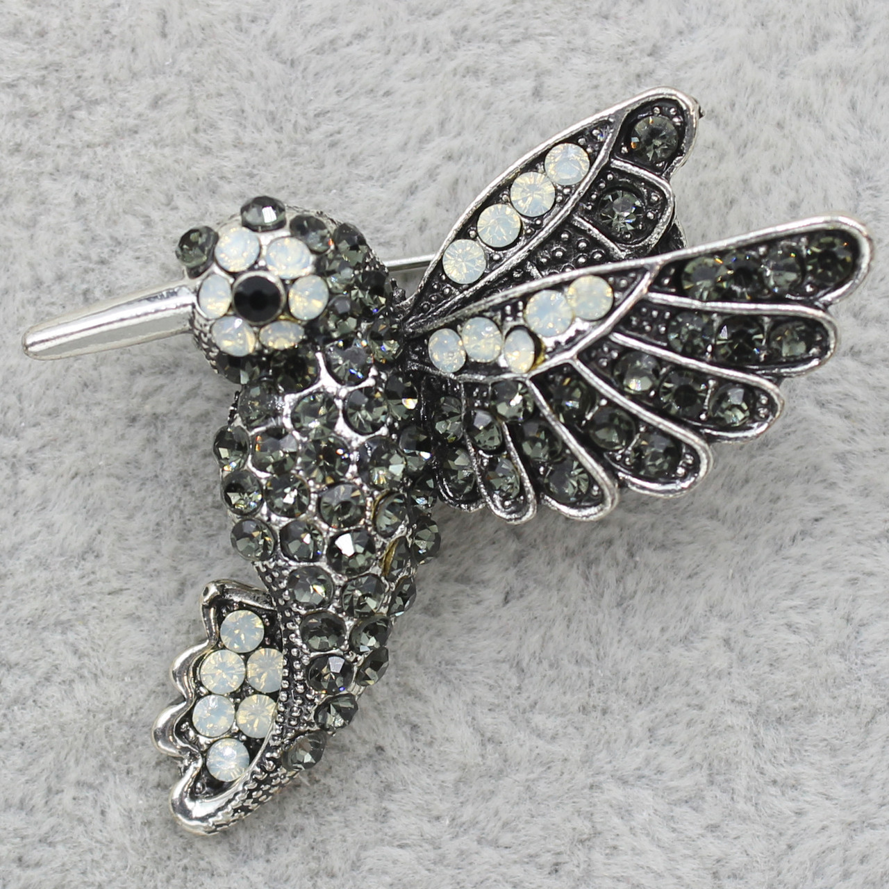 Брошка металева на сріблястій основі колібрі з різнобарвними кристалами розмір виробу 35х30 мм