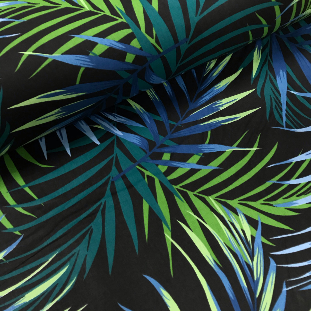 Сухие листья тропических пальм на фоне натуральной хлопковой ткани, вид сбоку