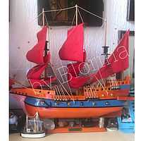 Дерев'яний корабель-вітрильник з червоними вітрилами