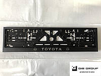 Рамка номерного знака c надписью и логотипом "Toyota" черная - надпись: белого цвета.