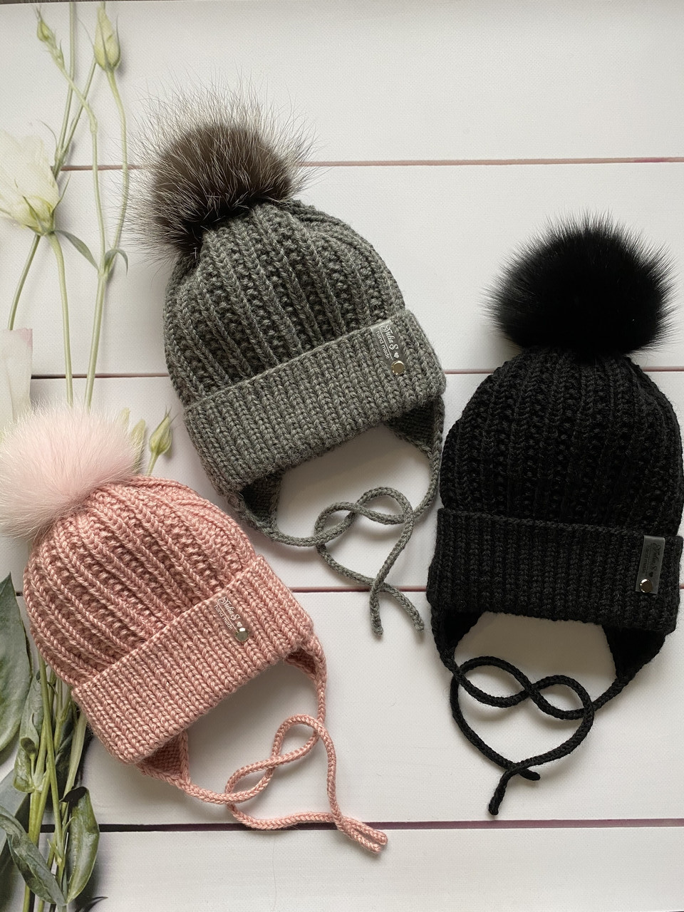 Зимова в'язана дитяча шапочка на зав'язках із натуральним бубоном для дівчинки ручної роботи.
