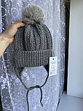 Зимова в'язана дитяча шапочка на зав'язках із натуральним бубоном для дівчинки та хлопчика ручної роботи., фото 5