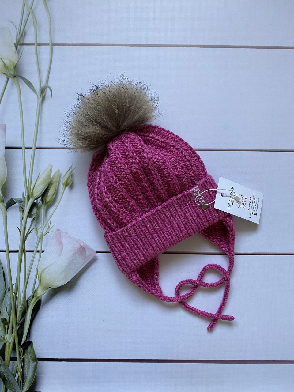 Зимова в'язана дитяча шапочка на зав'язках із натуральним бубоном для дівчинки ручної роботи.