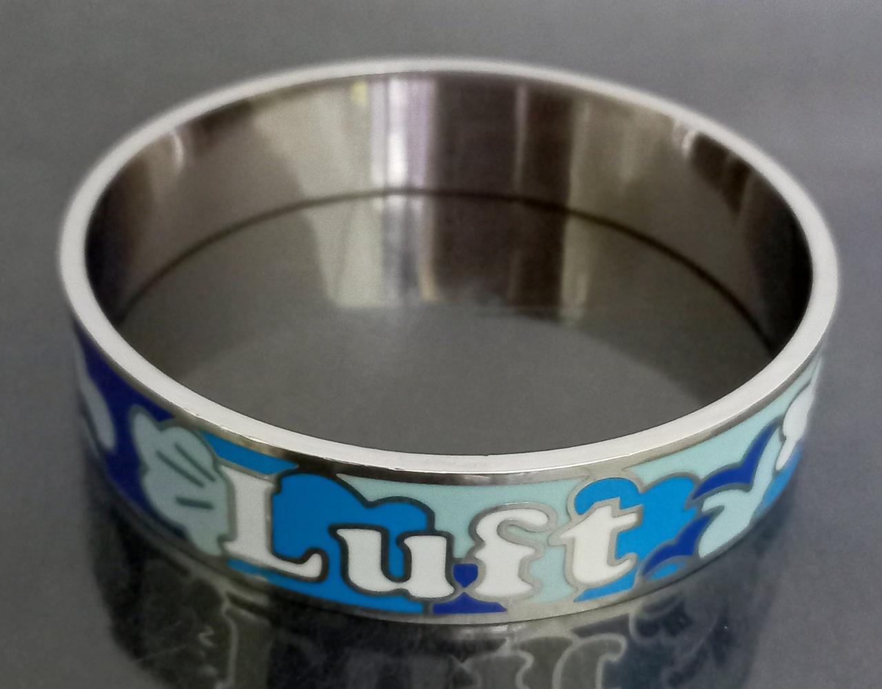 Браслет із сталі, покритий емаллю. Родій. Діаметр: 7 см. Ширина: 15 мм.