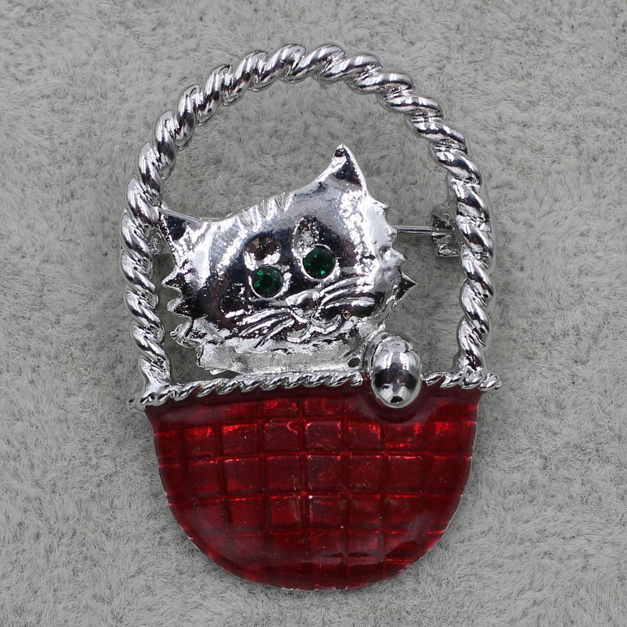 Брошка срібляста Кіт у червоному кошику з зеленими стразами покрита кольоровою емаллю розмір виробу 30х40 мм