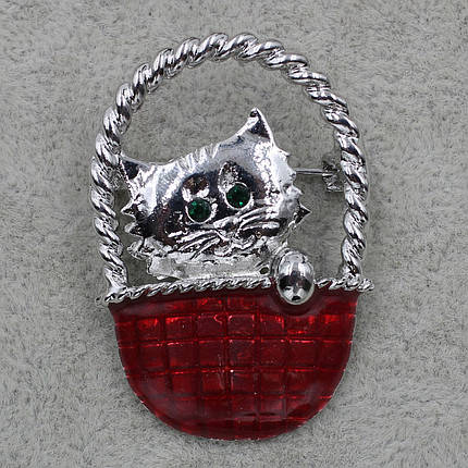 Брошка срібляста Кіт у червоному кошику з зеленими стразами покрита кольоровою емаллю розмір виробу 30х40 мм, фото 1