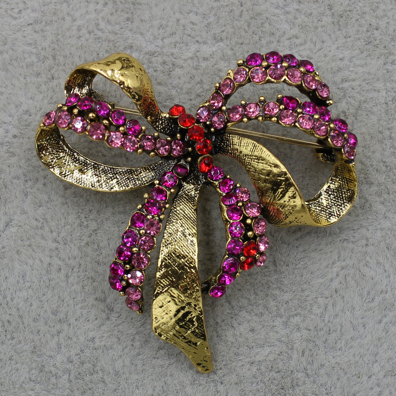 Брошка металева золотиста Бантик з інкрустованими кольоровими сапфірами розмір виробу 40х40 мм - фото 1 - id-p1543429091