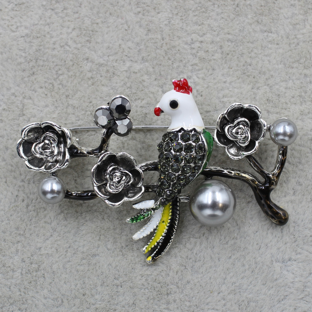 Брошка металева темно-срібляста з трояндочками, бусинами Папуга в стразах розмір виробу 50х40 мм