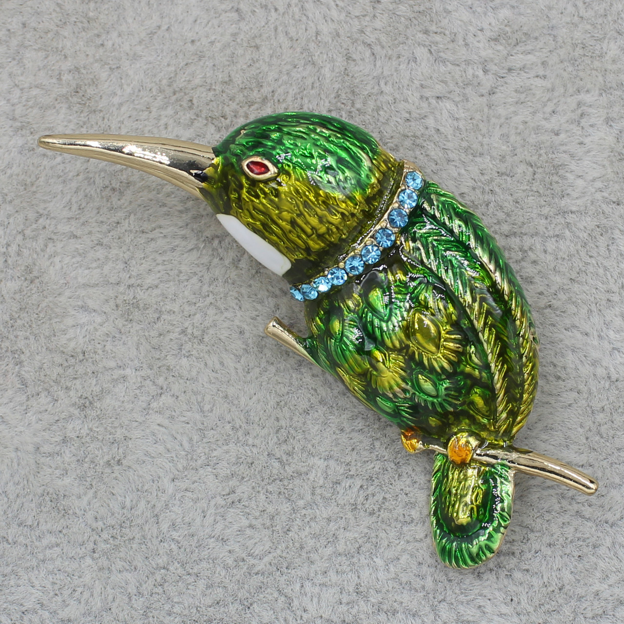 Брошка металева золотиста Пташка на гілочці в стразах покрита кольоровою емаллю розмір виробу 50х40 мм