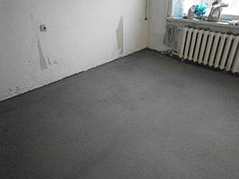 Плівка, що використовується для гідроізоляції і заходила внахлест на стіну, а також демпферна стрічка, що примикає до стіни, обрізані рівно за рівнем стяжки.