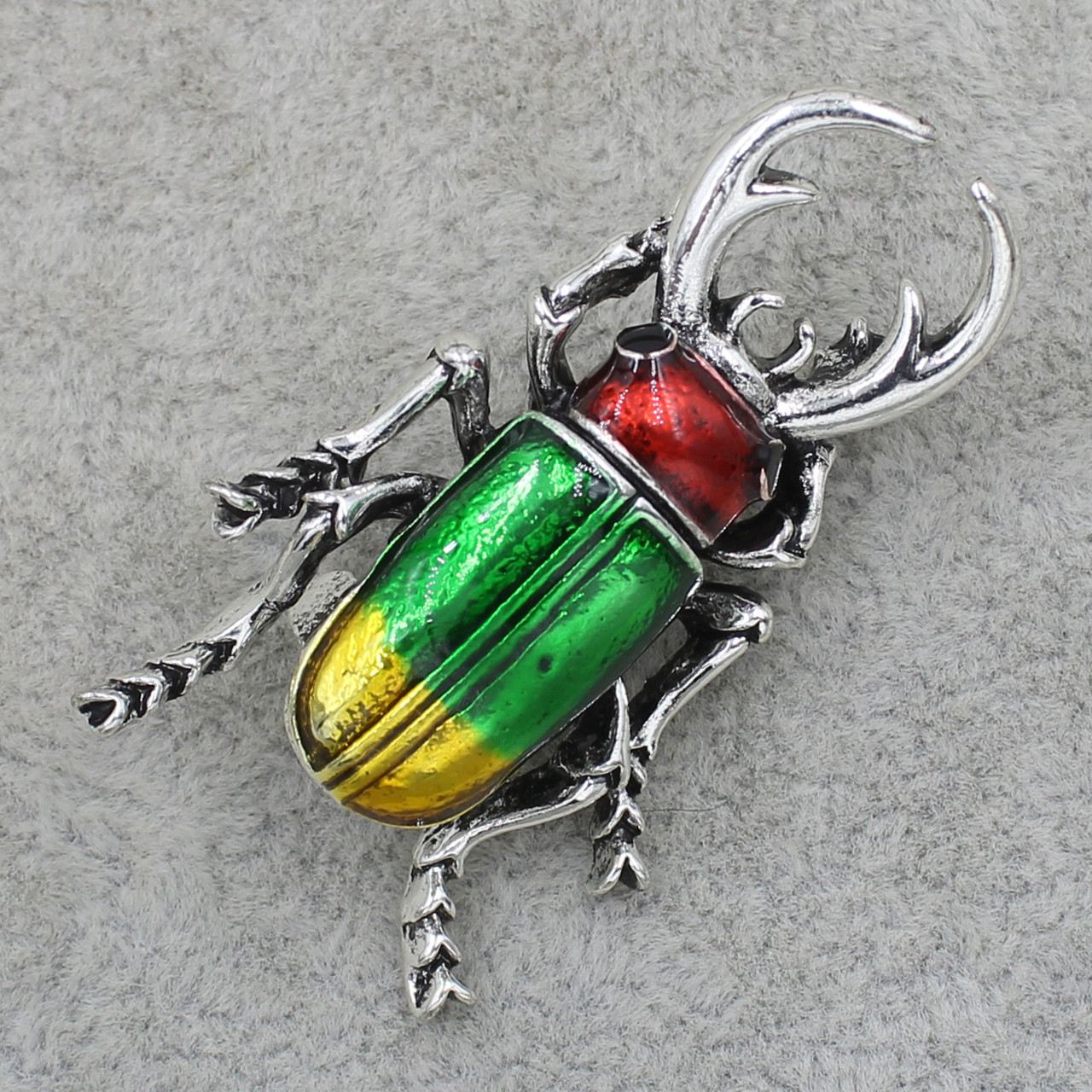 Брошка металева на сріблястій основі жук носоріг покритий кольоровою емаллю розмір виробу 40х20 мм