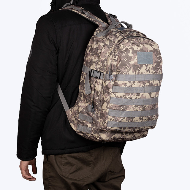 Фото чоловіка з камуфляжним рюкзаком Augur на спині