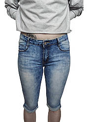 Бриджі джинсові жіночі блакитного кольору звужені донизу з закотами та середньою посадкою