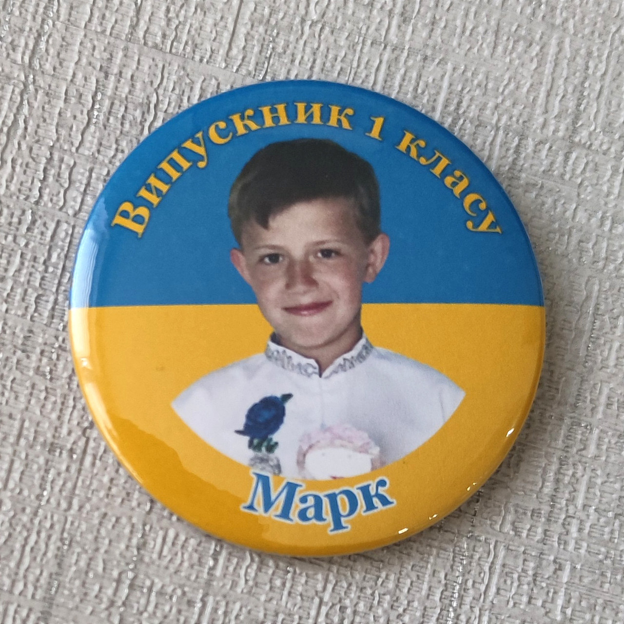 Значки для випускників з фотографіями на фоні прапора України