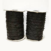 Квадратна пластикова кнопка на чорній стрічці.