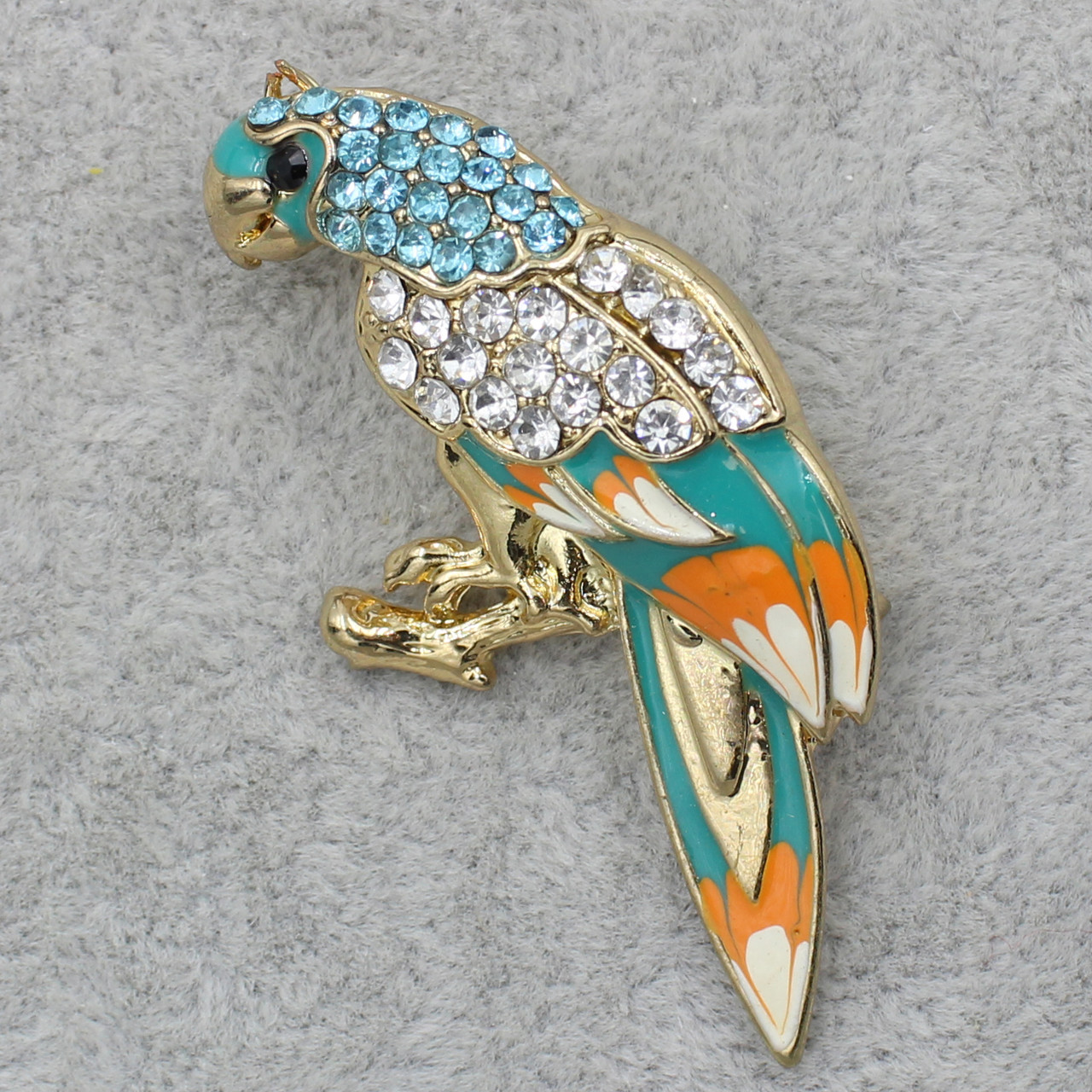 Брошка металева золотиста Папуга з різнобарвним хвостом із білими та блакитними стразами розмір 2,5 х 5 см