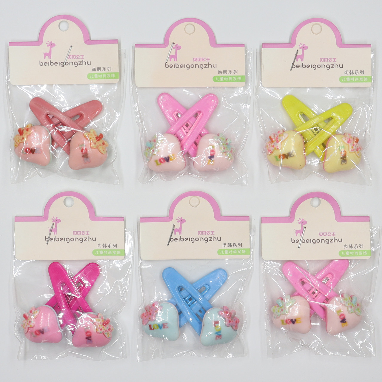 Набір шпильок дитячих хлопавки пластик упаковка 20 штук у стрічці полунички з написом love різних кольорів - фото 1 - id-p1663665825