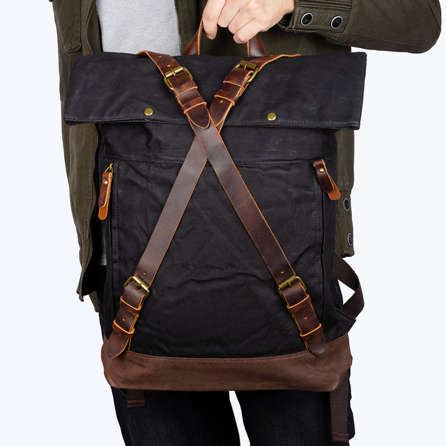 Фото чоловіка з міським вінтажним рюкзаком чорного кольору у руці